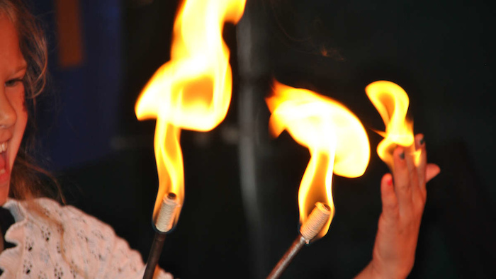 Frau spiet im Kreativcamp mit dem Feuer