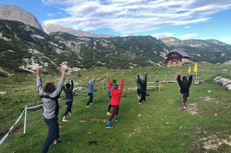 Familien laufen gemeinsam über eine malerische Landschaft in den Bergen