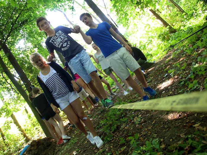 Dem Jungen auf der Slackline wird von anderen Kindern des Actioncamps Kappeln geholfen