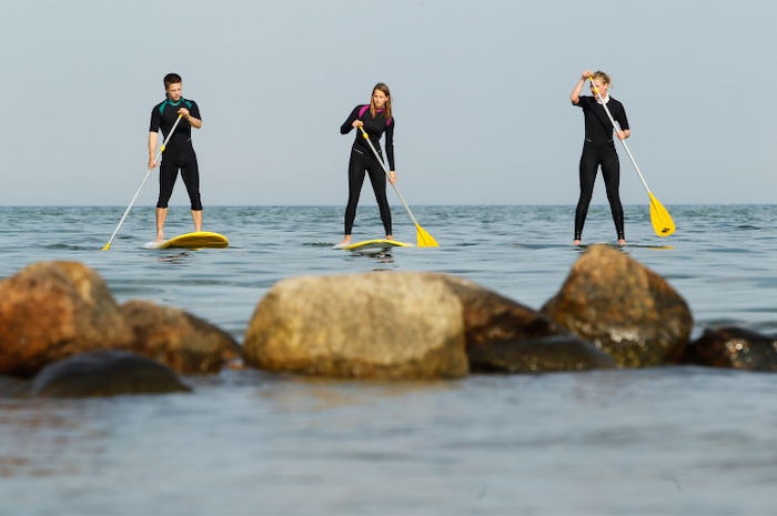 Teilnehmer einer Ferienbetreuung Bremen machen Stand-up-Paddling