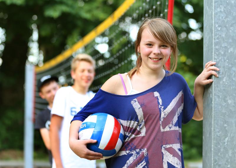 Ein Mädchen der Sprachreisen Abiturvorbereitung posiert mit einem Volleyball