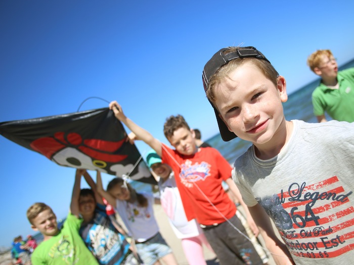 Junge und andere Kinder präsentieren Flagge im Actioncamp Otterndorf