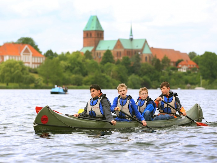 Jungen paddeln vor der Kulisse der Altstadt im Wassersportcamp Ratzeburg