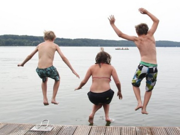 Kinder im Wassersportcamp Ratzeburg springen vom Steg ins Wasser