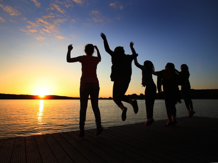 Gruppe springt in den Sonnenuntergang im Wassersportcamp Ratzeburg