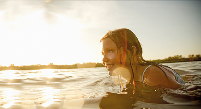 Jeune fille dans la mer en colo surf