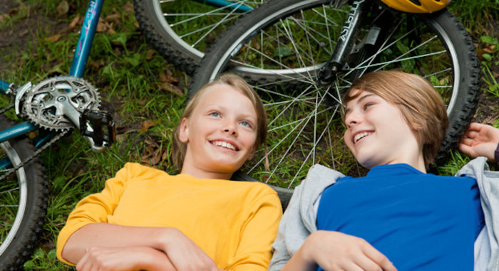 Kinder liegen neben dem Fahrrad im BMX Camp