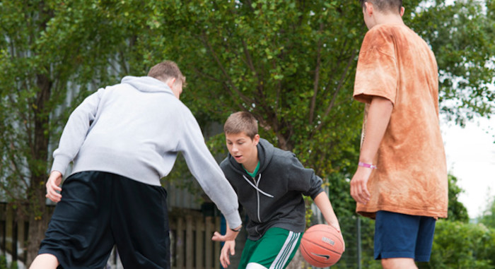 Jugendliche spielen Basketball im Englisch Camp in Hessen. 