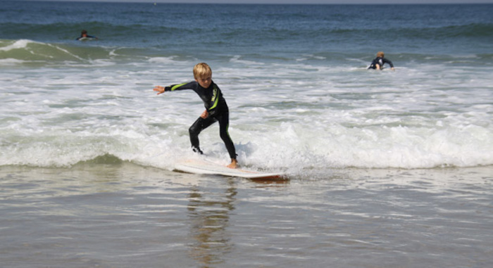 Junge surft auf einer Welle