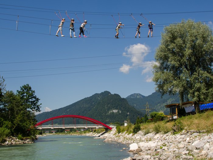 Kinder klettern im Hochseilgarten über einen Fluss im Actioncamp Österreich