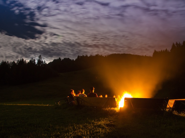 Gruppe um ein Lagerfeuer herum im Actioncamp Österreich