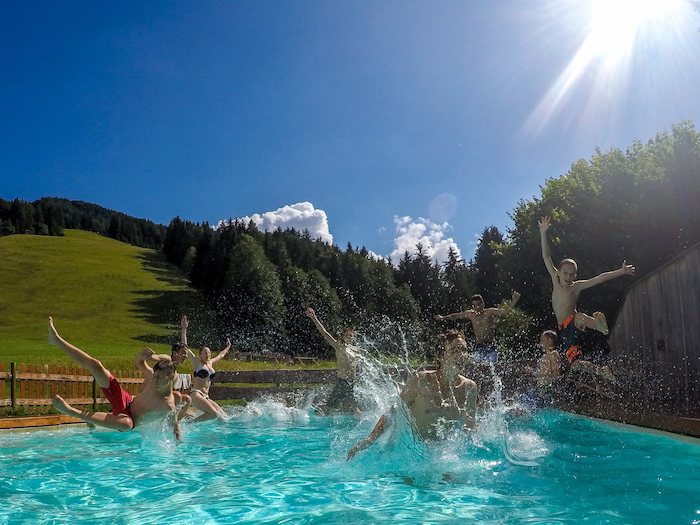 Gruppe springt in einen Pool im Actioncamp Österreich