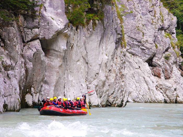Gruppe im Raftingboot vor Felsen im Actioncamp Österreich