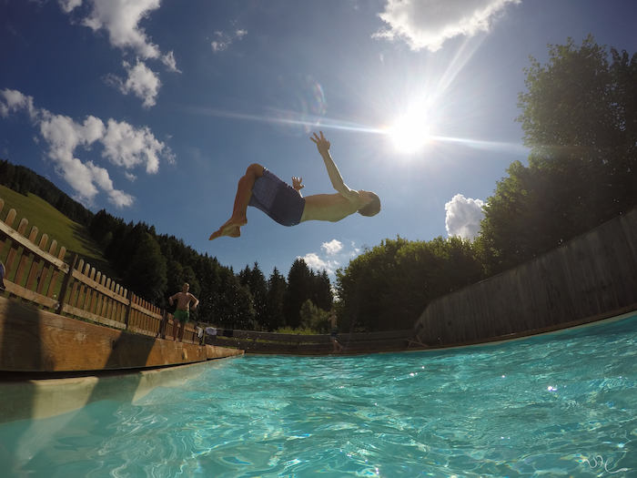 Junge macht einen Salto in den Pool im Actioncamp Österreich