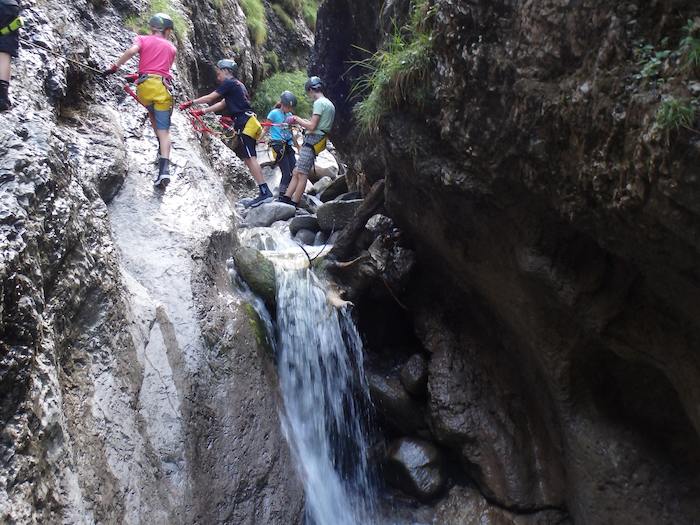 Kinder klettern an einem Wasserfall im Actioncamp Österreich
