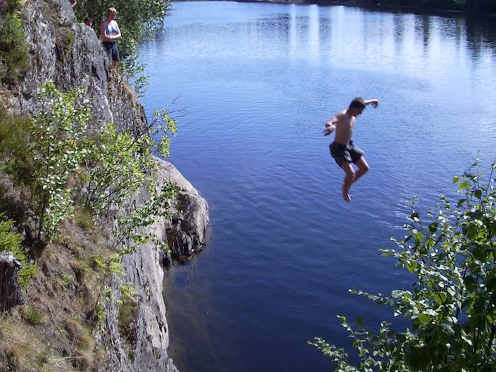 Junge springt von Klippe ins Wasser auf der Jugendreise Norwegen