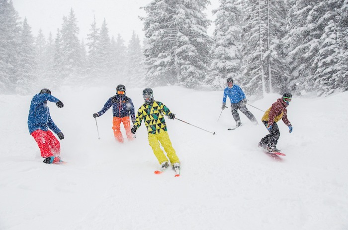 Cinq jeunes skieurs descendent une piste en colo ski ado 