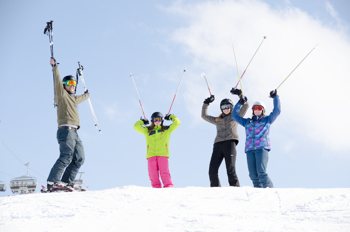 Gruppe hält Skistöcke in die Luft auf der Skifreizeit Österreich