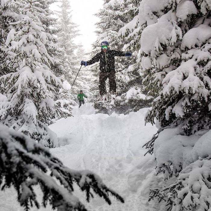 Skifahrer macht einen Trick im Wald auf der Skifreizeit Österreich