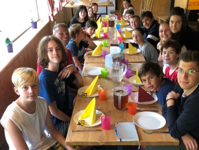Kinder sitzen am Tisch kurz vor dem Essen im Ferienlager auf Sylt