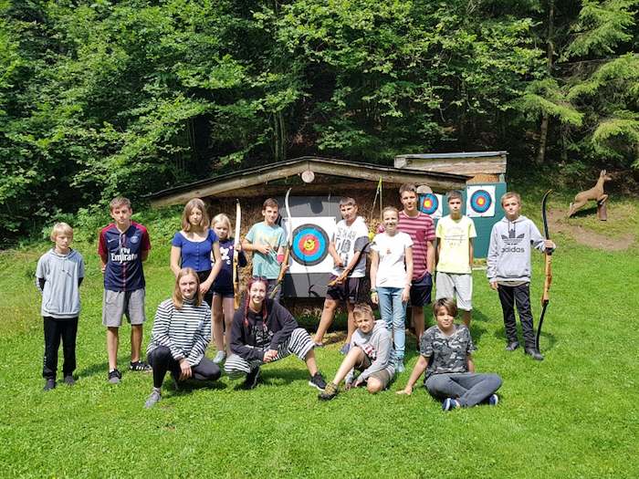 Eine Gruppe Kinder in dem Ferienlager Dänemark posen mit Bögen für ein Bild