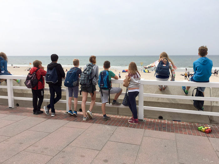 Gruppe sieht von der Strandpromenade aus auf den Strand im Ferienlager auf Sylt