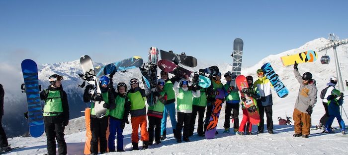 Gruppe hält ihre Snowboards in die Luft auf der Skifreizeit Österreich