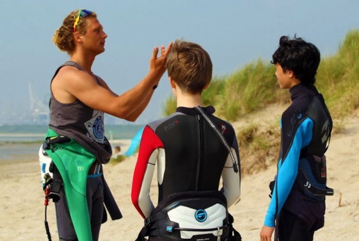 Ein Surflehrer bringt Kindern auf Jugendreise surfen bei