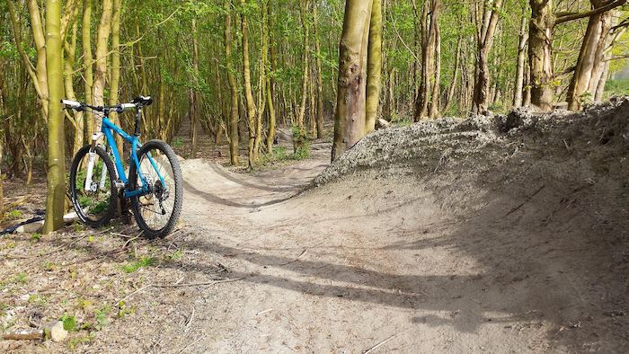 Ein Mountainbike steht auf Segelfreizeit IJsselmeer am Wald
