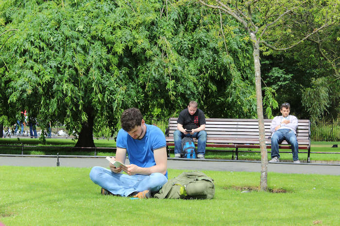 Chico leyendo en el parque en Dublín durante un curso de ingles en dublin