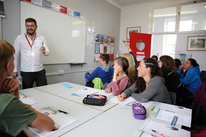 Die Kinder kommen zusammen in ihrem Herbstcamp im Klassenraum einer Fremdsprache näher