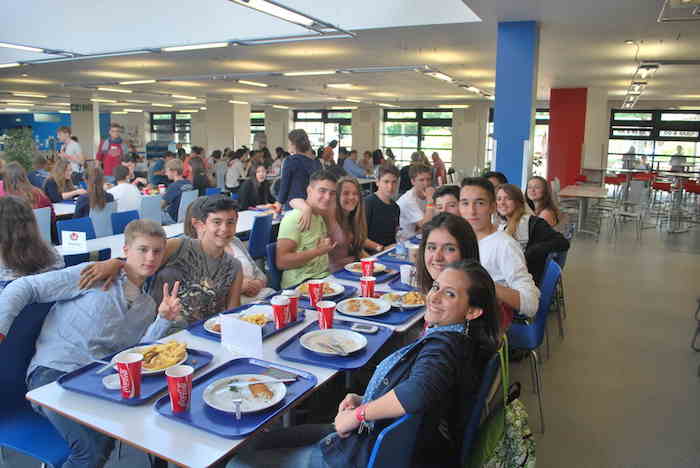 Auf der Sprachreise sitzen die Schüler gemeinsam in der Mensa am Tisch