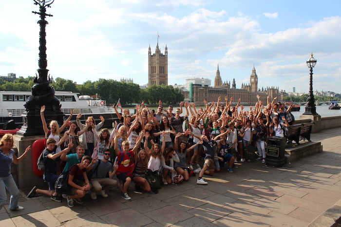 Groupe d'adolescents levant les bras devant la Tamise lors d'un voyage linguistique Londres