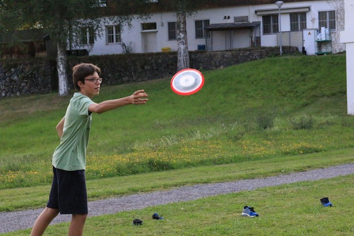 Junge wirft Frisbee im Lerncamp in Baden-Württemberg