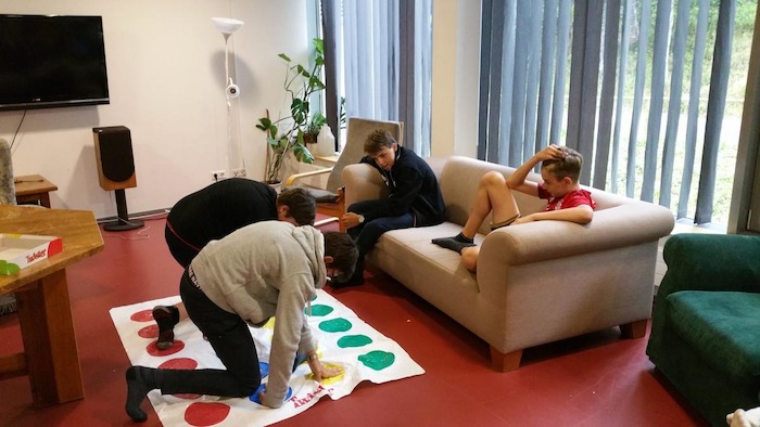 Kinder chillen auf er Couch und spielen Twister im Gemeinschaftsraum im Lerncamp in Baden-Württemberg