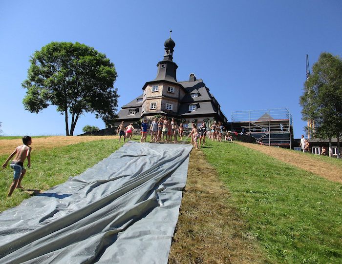 Kinder spielen auf der Wasserrutsche im Nachhilfe-Camp in Baden-Württemberg