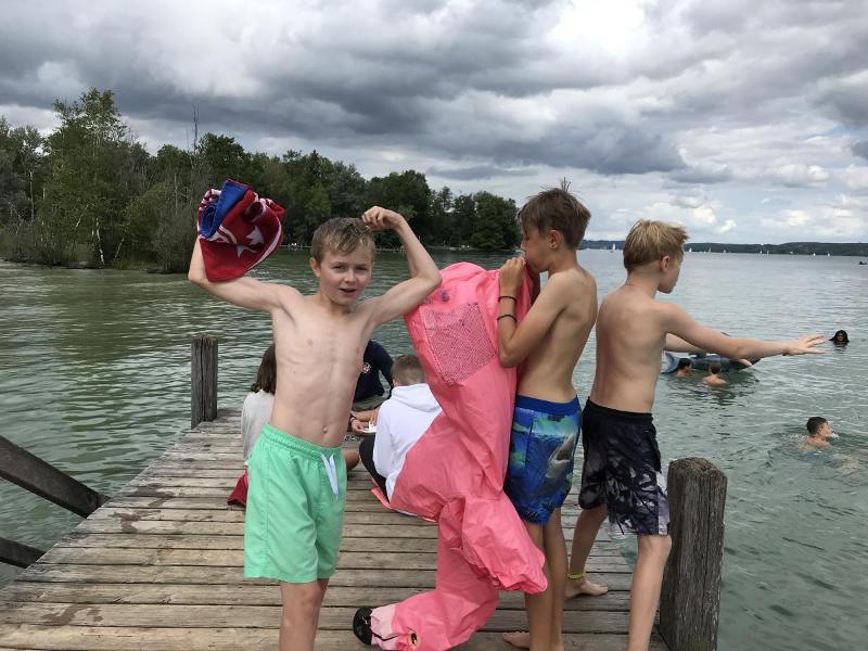 Eine Gruppe Jungs spielt an einem Bootssteg am See im Englisch-Camp Pfingstferien