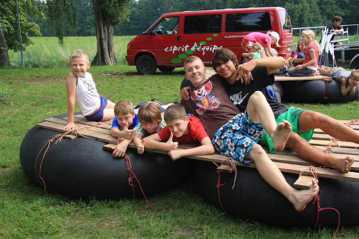 Kinder auf selbstgebautem Floß auf dem Land im Ferienlager im Spreewald