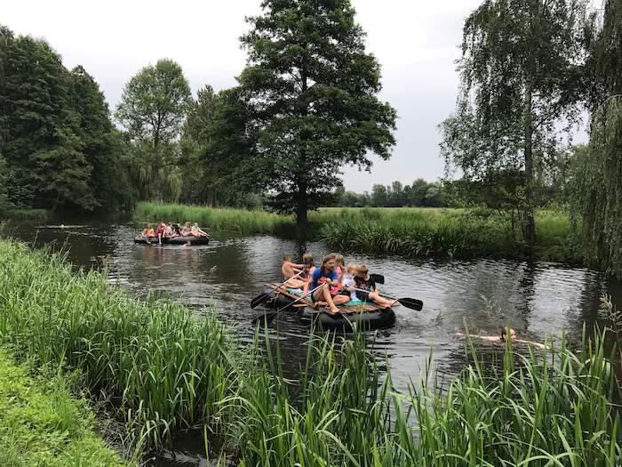 Kinder sitzen auf zwei Flößen auf dem Fluss im Ferienlager im Spreewald