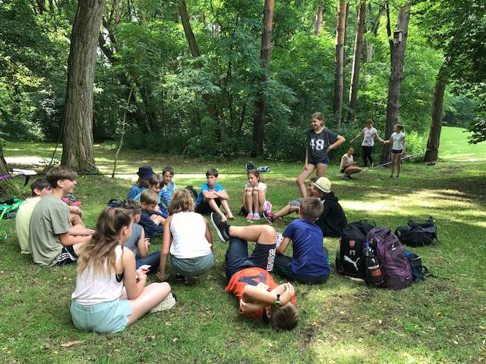 Gruppe sitzt im Wald im Ferienlager im Spreewald