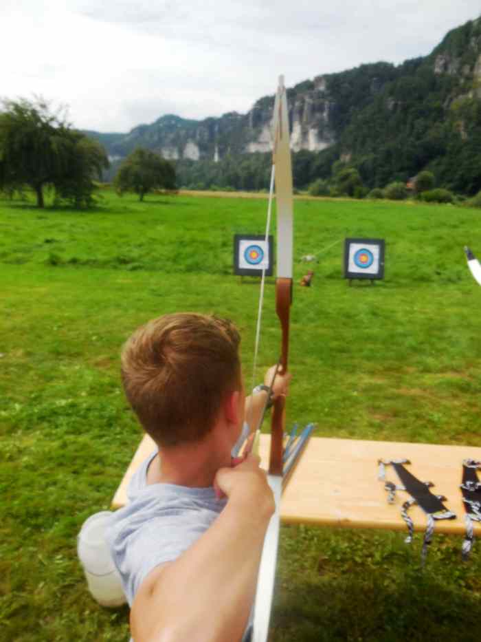Ein Junge übt Bogenschießen im Jugendlager
