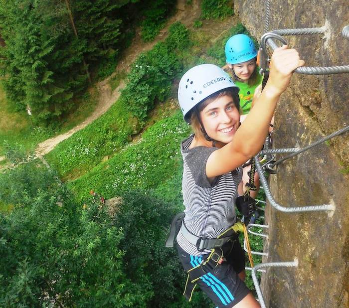 Im Herbstcamp klettern die Kinder grade an einer Felswand hoch