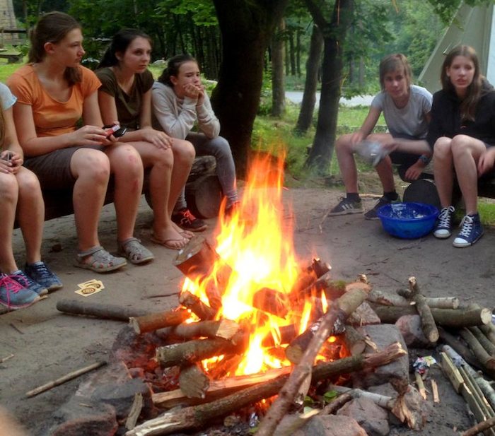 Die Gruppe relaxt nach einem langen Tag auf Kanureise am Lagerfeuer