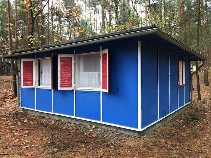 Blaues Bungalow im Wald im Ferienlager in Brandenburg