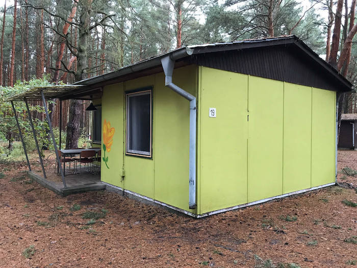 Grünes Bungalow im Wald im Ferienlager in Brandenburg