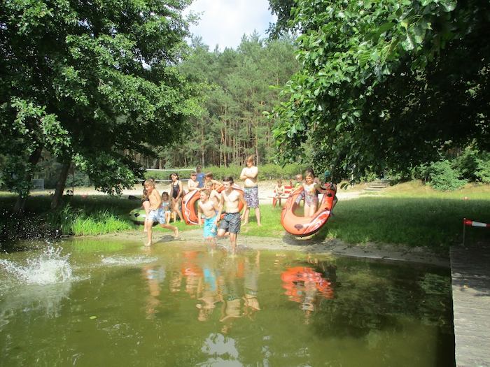 Kinder rennen in den See im Action-Feriencamp bei Berlin