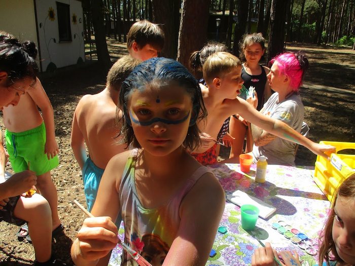 Kinder malen sich bunt an im Action-Feriencamp bei Berlin