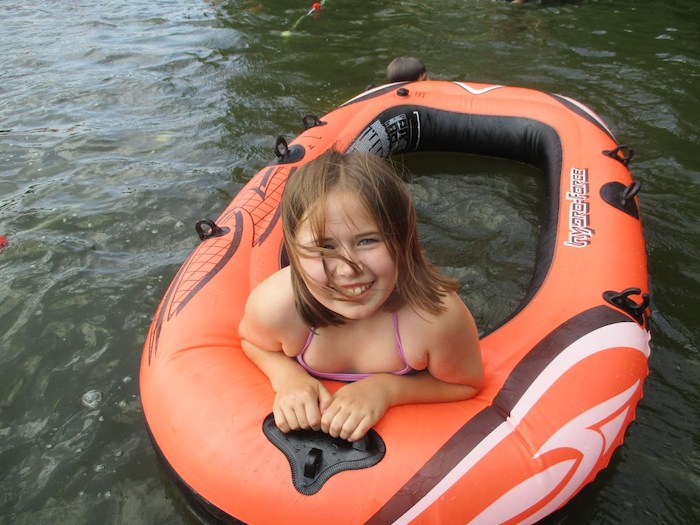 Ein Mädchen lächelt im Wasser auf der Kinderreise