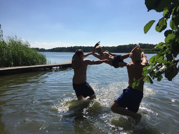 Kinder werfen sich gegenseitig ins Wasser im Ferienlager in Brandenburg