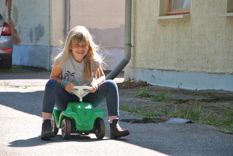 Kinder der Herbstferien Berlin fahren Bobbycar draußen